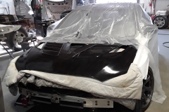 Evo X with protective wrap over the winshield and a blanket protecting the engine