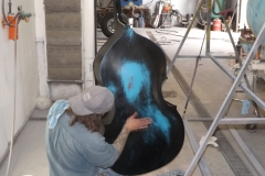 Action shot of the blue bass being painted with distressed effect blue