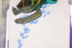 Side two of a snowboard with a certain  cartoon turtle ready to jump into the current